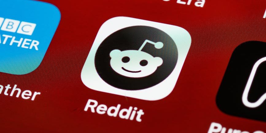 Detailed view of the Reddit app icon on a smartphone screen displaying popular applications.